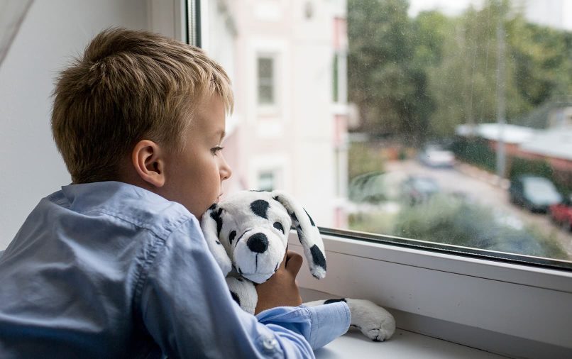 enfant qui regarde par la fenêtre
