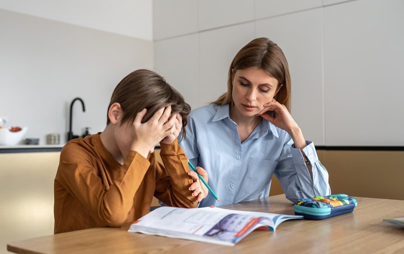 un enfant en train de faire ses devoirs avec sa mère